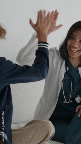 Kind pediatrician reassuring a young boy at a doctor's appointment, fostering a warm and caring environment before sharing a cheerful high five with him