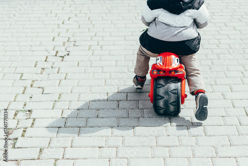 Back view of little boy on bogie wheel, partial view