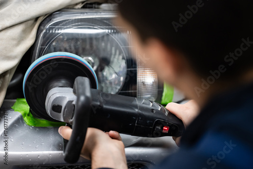 фотографія Mechanic polishing car headlight restoring clarity and vision