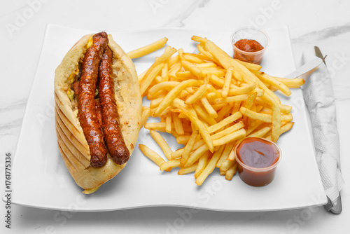 Sandwich merguez sur une assiette avec des frites et sauces. Spécialité culinaire turque. Restauration rapide.	Doner kebab. 