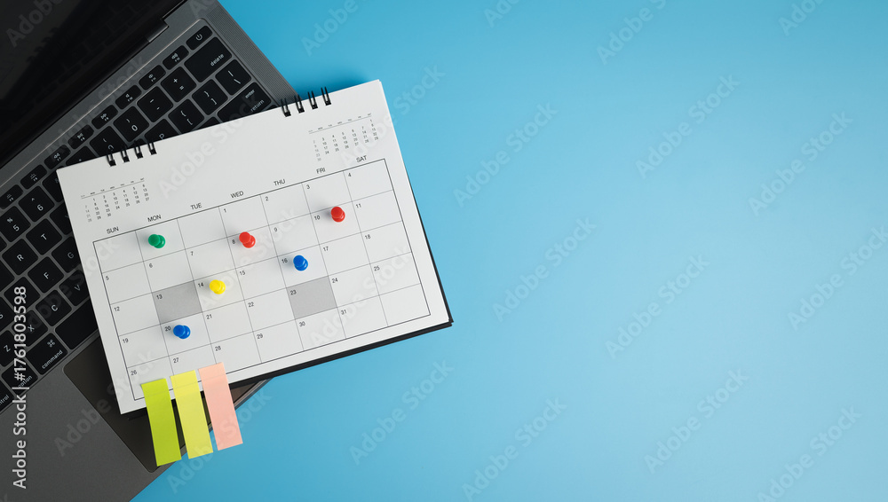 Fototapeta premium Pinned to the calendar with laptop on desk, symbolizing time management, business meeting planning, appointments, travel planning. flat lay