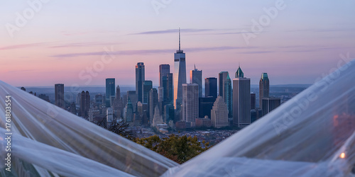 City skyline glows at dusk, bathed in soft pink and blue hues, tranquil scene.
