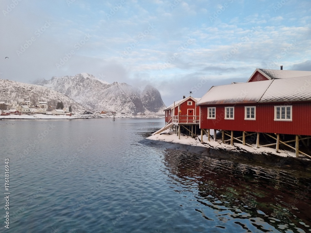 Fototapeta premium Lofoten Islands, Reine, Norway and Hamnoy fishing village with red rorbuer houses in winter sunset landscape 