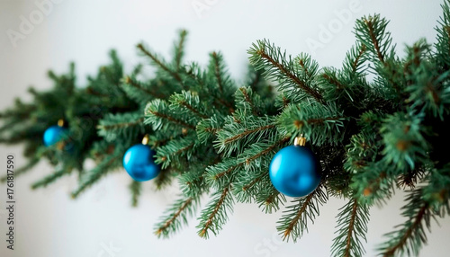 Wallpaper Mural Christmas garland of fir branches with blue Christmas tree decorations. Against a white wall. Generated by AI. Torontodigital.ca