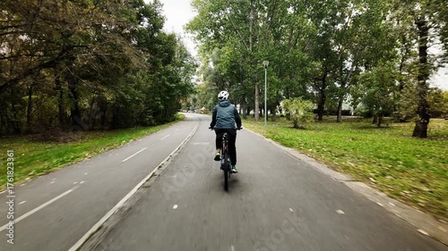 Wallpaper Mural 4K footage of a woman riding a bicycle along autumn forest path on Ada Ciganlija Island in Belgrade, Serbia. Rear view. Peaceful atmosphere and active outdoor lifestyle Torontodigital.ca