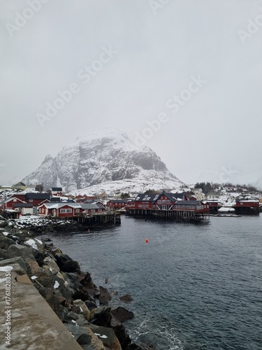 small fishing village of A (Moskenes) at the end of the road of the Lofoten islands archipelago in northern Norway - Red rorbuer on stilts in winter at dawn in a fjord
