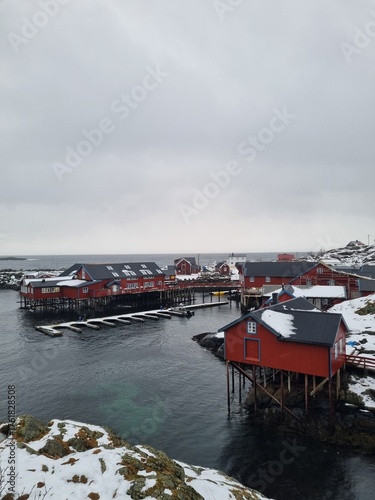 small fishing village of A (Moskenes) at the end of the road of the Lofoten islands archipelago in northern Norway - Red rorbuer on stilts in winter at dawn in a fjord
