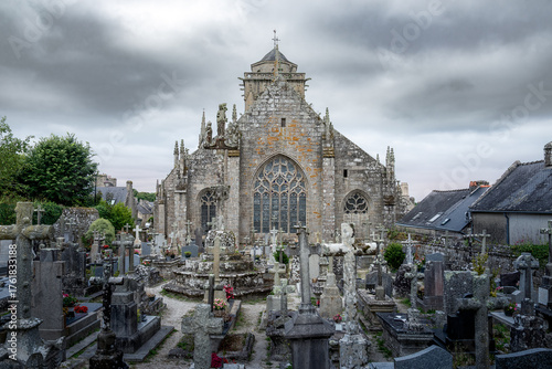 Spectacular view of the cathedral of Saint Ronan and cemetery in the small village of Locronan,  Finistère department, Brittany, France, during a cloudy summer morning.