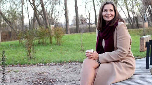 Charming young woman drinking coffee in park, tranquility, enjoying nature, copy space
