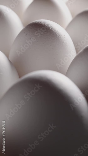 A side view of cascading orderly rows of white eggs. Light accentuates their contours, creating a sophisticated, premium product video.