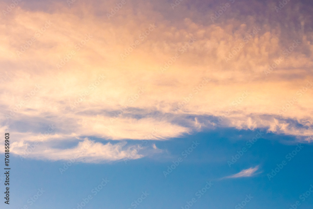 Obraz premium orange cloud on blue sky at sunset. beautiful nature background at dusk for meteorology. cloudscape in yellow light. abstract scene of summer weather
