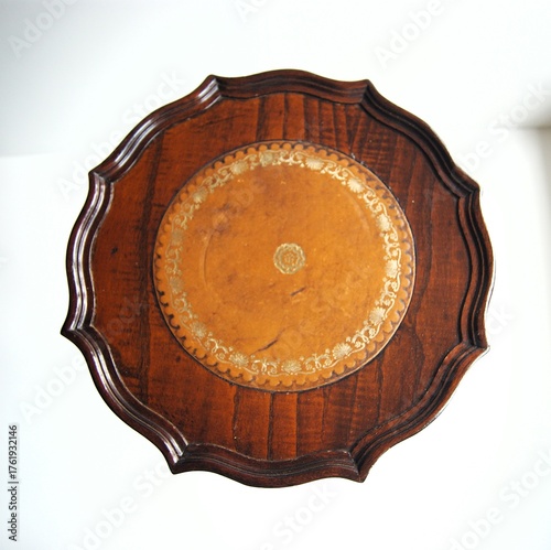 Top of antique table top with brown leather.