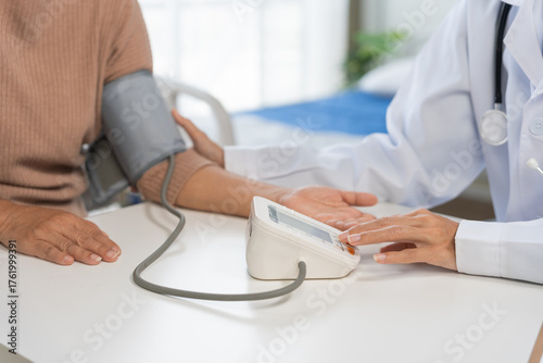Doctor checking blood pressure for a senior patient, focusing on health, prevention, and regular medical checkup in a hospital