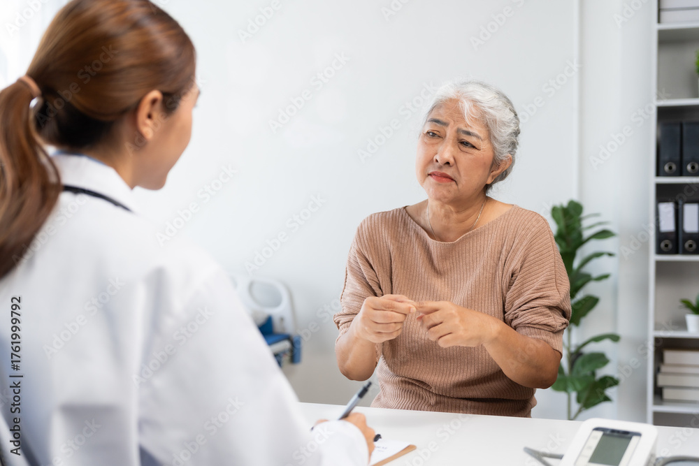 Fototapeta premium Senior patient discussing health concerns with female doctor in a clinic, receiving medical advice and support