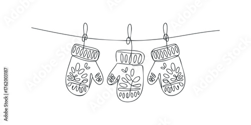 Three mittens hanging on a line with drawn floral designs