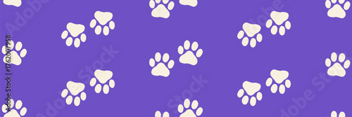 Seamless dog paw pattern with funky doggy prints for pet foot designs or animal themed projects. A vector pattern of cute paw prints on a purple background