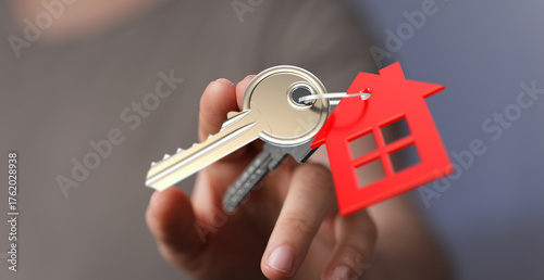 Hand holding keys with hous...