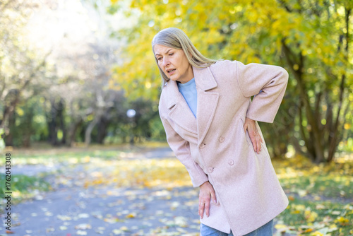 Obraz na plátne Senior woman feeling acute back pain outdoors