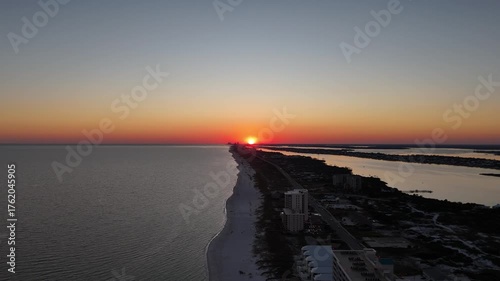sunset on the beach wide drone shot lowers 