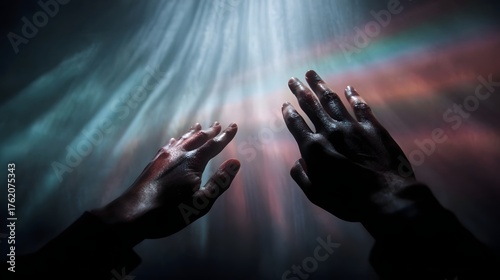 Hands reaching towards vibrant rainbow light beams in a dark glowing atmosphere