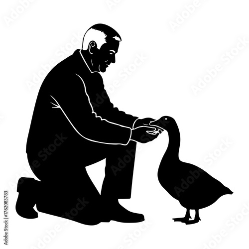 Man kneeling feeding duck bird