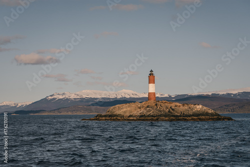 Paisaje del islote Les Eclaireurs en Tierra del Fuego con el faro tradicional en la tarde. Al fondo los andes nevados. Patagonia argentina. 