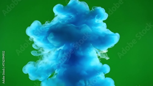 Vibrant blue ink cloud swirling in bright green liquid, creating an abstract and energetic explosion of color.