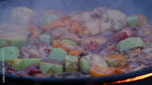 vegetables fried in a cauldron over a fire, close-up
