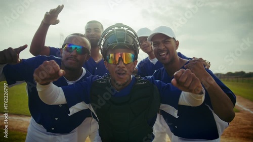 Players celebrate their game victory on the diamond. Teamwork and success are evident as they cheer with excitement.