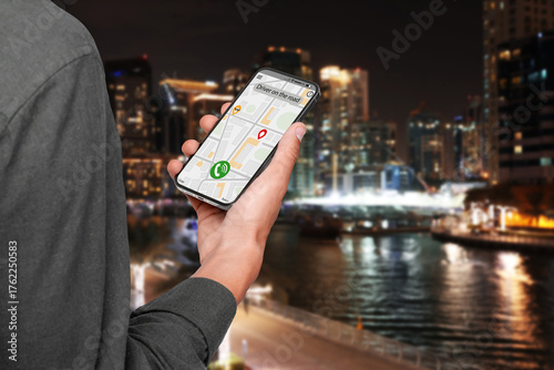 Photography Man using app on mobile phone to call taxi on city street in evening, closeup