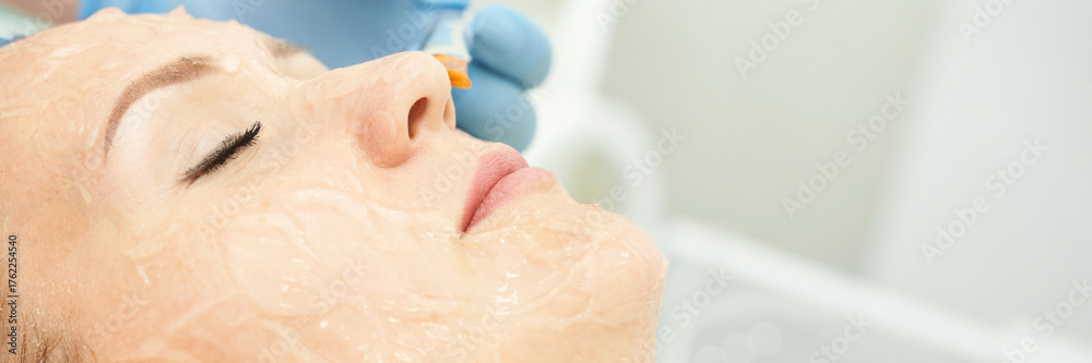 Fototapeta premium Female caucasian adult receiving facial treatment with chemical peel and syringe at spa.