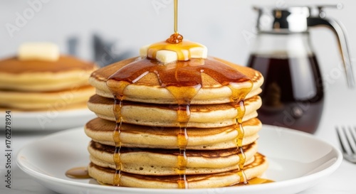 Stack of fluffy pancakes butter syrup drizzled on top