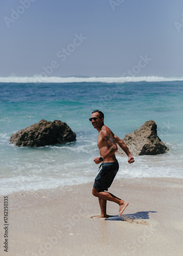 man playing and smiling on the beach