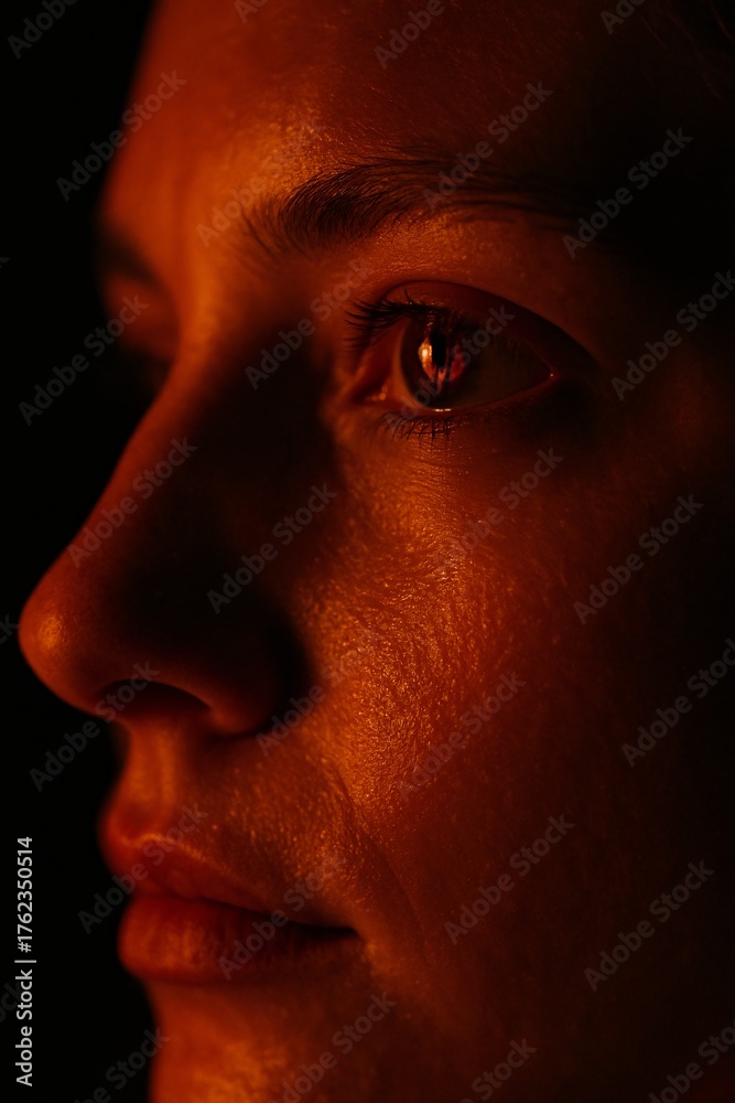 Naklejka premium Close up portrait with dramatic orange side lighting