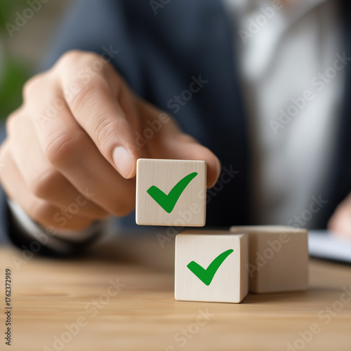 School leader placing cube with green checkmark representing academic integrity, policy adherence, and quality assurance in administrative office- 
