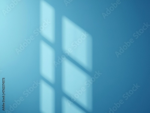 Serene blue wall bathed in soft, geometric window light creating a calming, minimalist backdrop for modern design concepts and peaceful ambiance