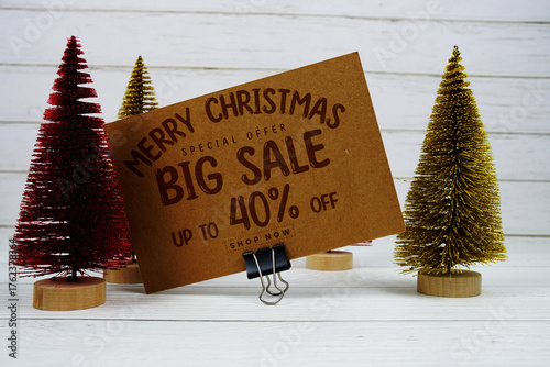 Festive display with small decorative Christmas trees with "Special Offer Merry Christmas Big Sale up to 40% off, Promotion Holiday Sale Event
