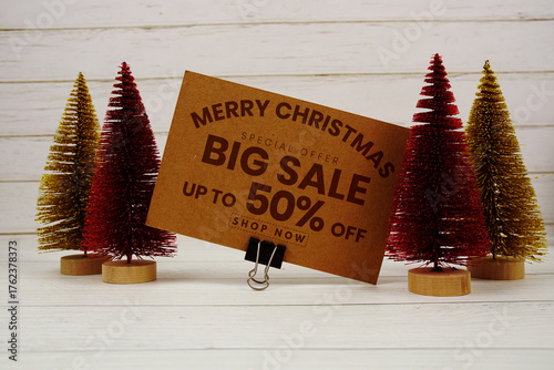 Festive display with small decorative Christmas trees with "Special Offer Merry Christmas Big Sale up to 50% off, Promotion Holiday Sale Event