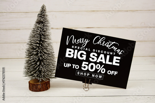 Festive display with small decorative Christmas trees with "Special Offer Merry Christmas Big Sale up to 50% off, Promotion Holiday Sale Event