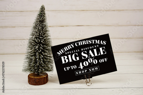 Festive display with small decorative Christmas trees with "Special Offer Merry Christmas Big Sale up to 40% off, Promotion Holiday Sale Event