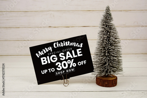 Festive display with small decorative Christmas trees with "Special Offer Merry Christmas Big Sale up to 30% off, Promotion Holiday Sale Event