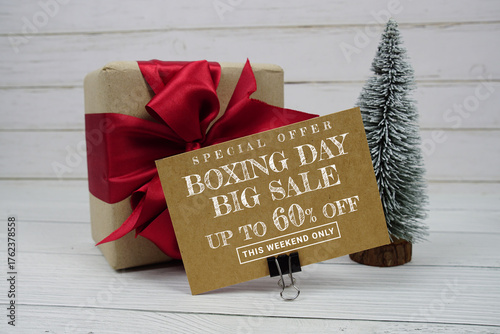 Festive display with small decorative Christmas trees and gift box present with "Special Offer Boxing Day Big Sale up to 60% off, Promotion Holiday Sale Event