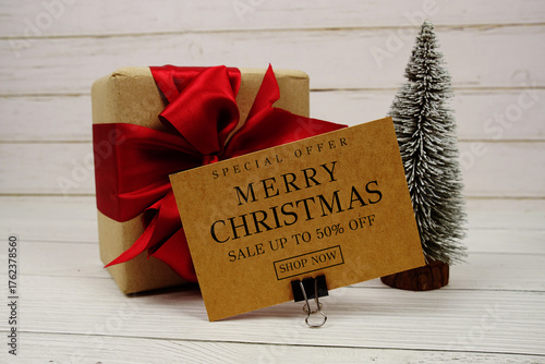 Festive display with small decorative Christmas trees and gift box present with "Special Offer Merry Christmas Big Sale up to 50% off, Promotion Holiday Sale Event