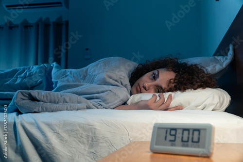 Young woman suffering from insomnia having trouble sleeping