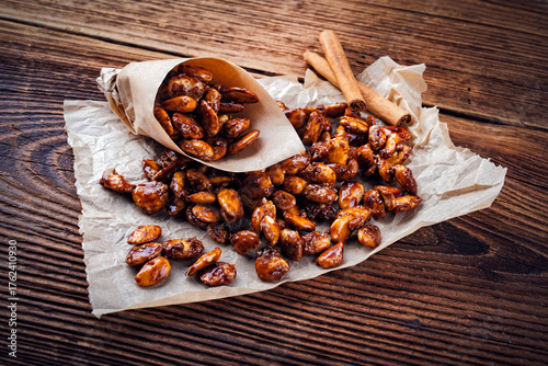 Candied almonds - homemade burnt sugar caramelized almonds served as close-up on a wooden board