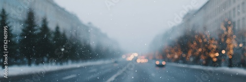 Blurry shot of a snowy street with cars and trees