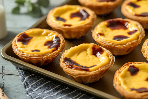Golden, custard-filled pastries on a baking sheet, showcasing a delicious, sweet treat.