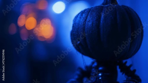 Dark Halloween Pumpkin Decoration with Glowing Orange Eyes and Eerie Smile in Blue Light