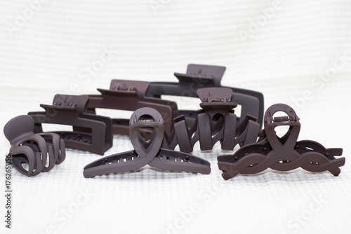 Brown hair clips on plain background 