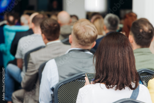 Audience at the modern conference hall listens to panel discussion, people on a congress together listen to speaker on stage at convention, plenary session at business seminar, venue for presentation